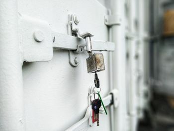 Close-up of metal chain against white wall