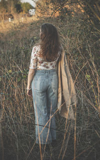 Rear view of woman standing on field