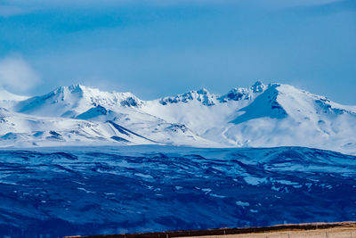 Scenic view of snow covered mountain against cloudy sky