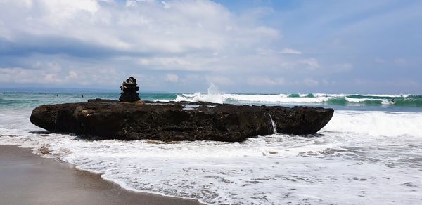 Rock formation on beach against sky