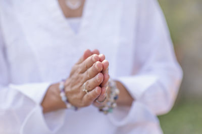 Midsection of woman gesturing while praying