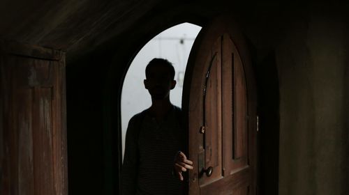 Rear view of man standing against door