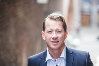 Portrait of smiling mature businessman in city