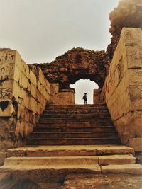 Low angle view of steps amidst buildings against sky