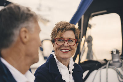 Smiling senior woman looking at man while traveling in yacht