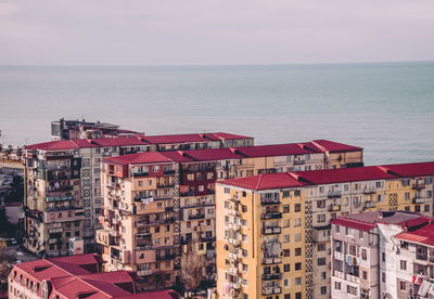 High angle view of buildings by sea against sky