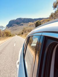 Car on road against clear blue sky