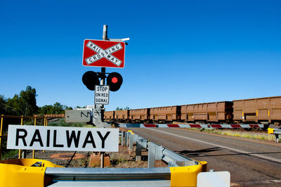 Road sign against clear blue sky