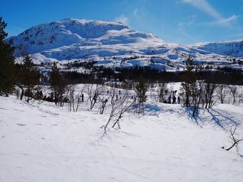 Snow covered land and mountains against sky