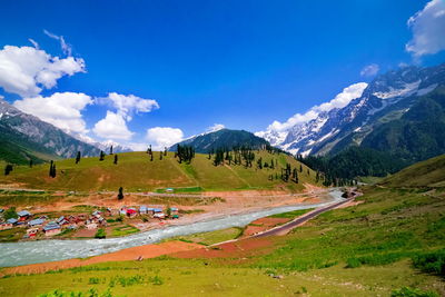 Scenic view of landscape and mountains against blue sky