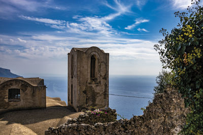 Castle by sea against blue sky