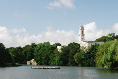 Scenic view of river by building against sky