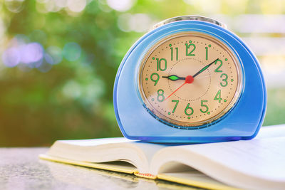 Close-up of clock on open book