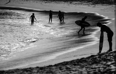 Silhouette people enjoying at sea shore