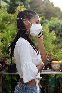 Young black woman in face mask speaking on the phone