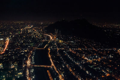 High angle view of illuminated city against sky at night