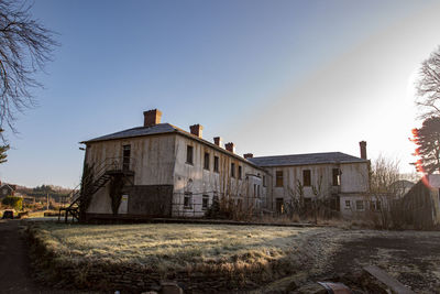 Houses on field against clear sky during winter