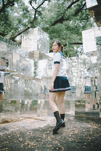 Full length of a smiling young woman standing outdoors