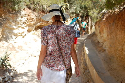 Rear view of woman walking on footpath