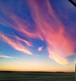 Scenic view of field against sky at sunset