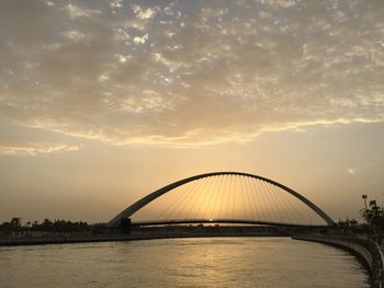 Bridge over river against sky during sunset