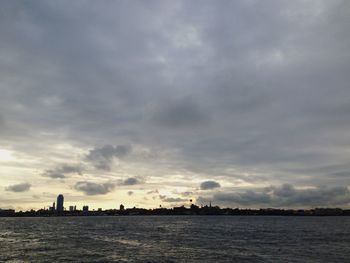 Scenic view of sea against cloudy sky at sunset