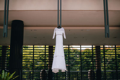 Low angle view of wedding dress hanging on building