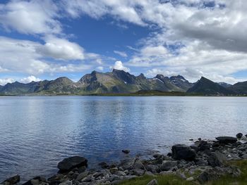 Scenic view of sea by mountains against sky