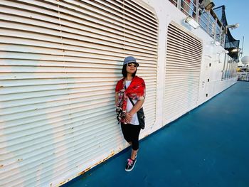 Woman wearing sunglasses standing in ship