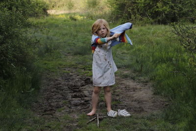 Full length of boy holding toy while standing on land