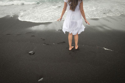 Low section of woman standing on beach