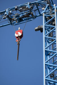 Low angle view of chain swing ride against clear blue sky