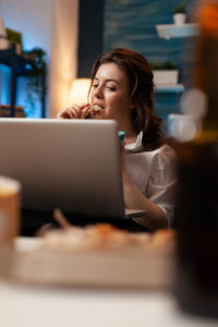 Woman using mobile phone while sitting on table