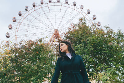 Low angle view of woman standing in amusement park