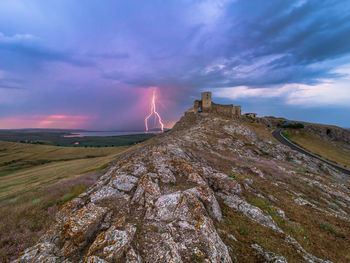 Panoramic view of rocks on land against sky during sunset