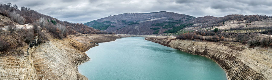 Scenic view of river amidst mountains against sky