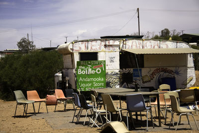 Empty chairs and tables by food truck