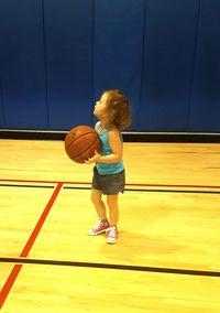 Full length of girl playing basketball