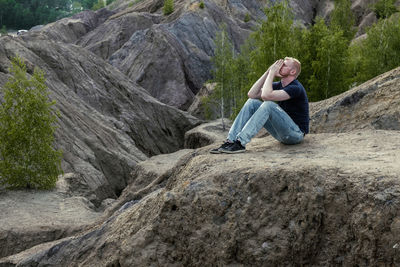 Full length of man sitting on rock