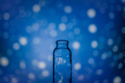 Close-up of glass bottle against blue background