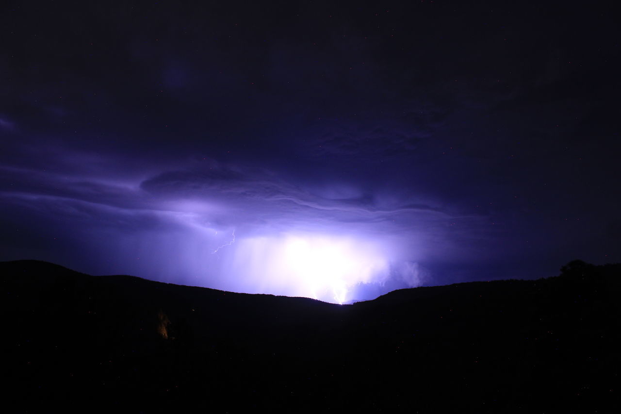 sky, darkness, beauty in nature, night, cloud, lightning, mountain, power in nature, environment, scenics - nature, storm, silhouette, thunderstorm, dramatic sky, nature, dark, landscape, no people, thunder, light, awe, outdoors, warning sign, storm cloud, mountain range, dusk, star, moonlight