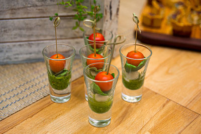 Caprese canapes in glass stacks. cherry tomatoes, mini mozzarella balls, pesto sauce.