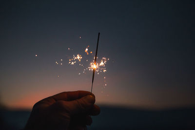 Close-up of hand holding sparkler at night