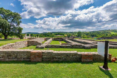 View of old ruin on field against cloudy sky