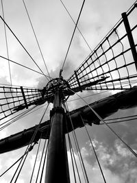 Low angle view of ferris wheel against cloudy sky