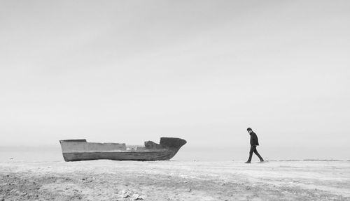 Man on beach against clear sky