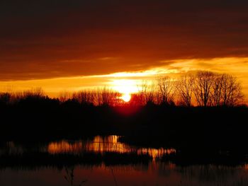 Scenic view of lake against romantic sky at sunset