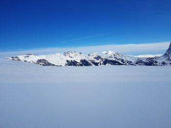 Scenic view of snowcapped mountain against blue sky