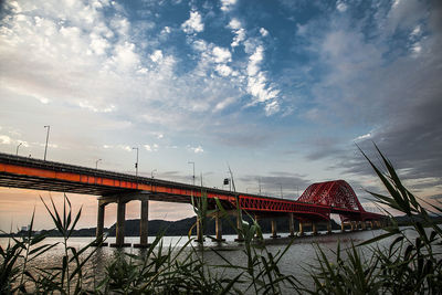 Low angle view of bridge against cloudy sky