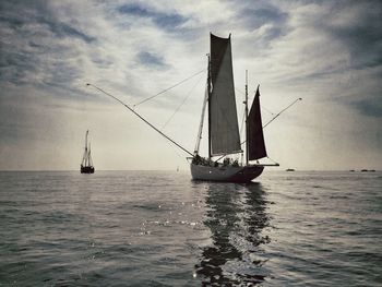 Sailboat sailing on sea against sky